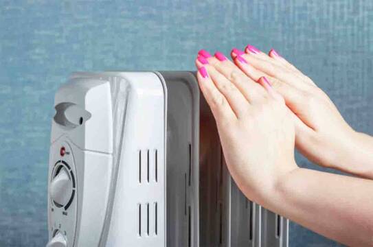Estufa eléctrica con manos calentándose