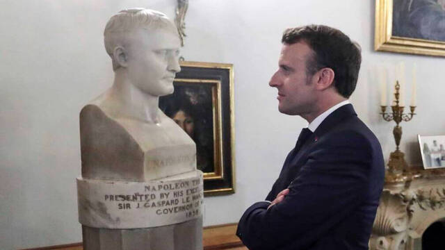 Emmanuel Macron mirando un busto de Napoleón Bonaparte