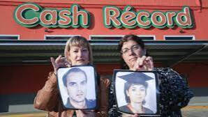 Familiares de Esteban y Elena sujetan sus imágenes frente al lugar donde ocurrió el crimen. 