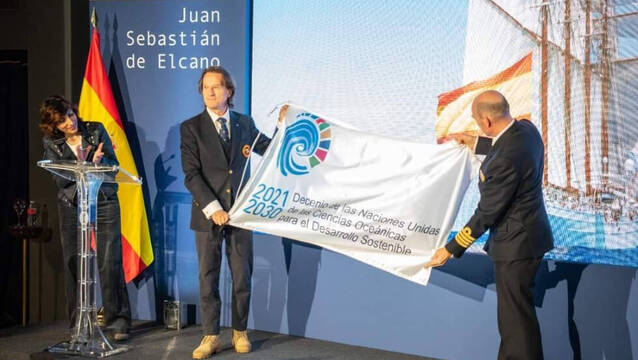 Kitín Muñoz haciendo entrega de la bandera del Decenio de los Océanos de las Naciones Unidas.