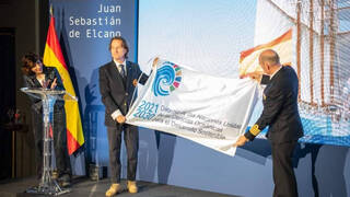 Kitín Muñoz, embajador de la UNESCO, entrega la bandera de Naciones Unidas al Juan Sebastián Elcano