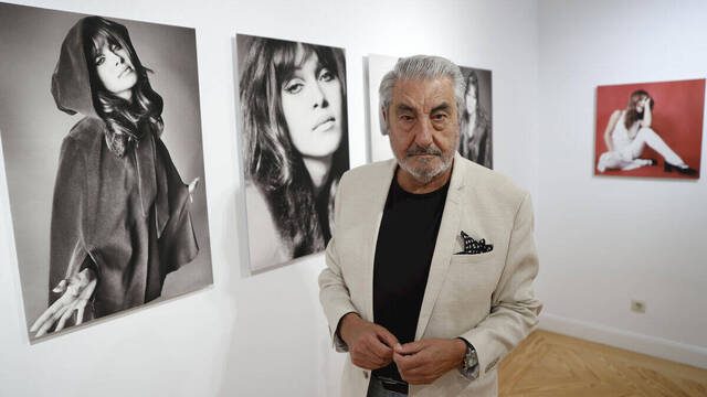César Lucas junto alguno de los retratos de la exposición.