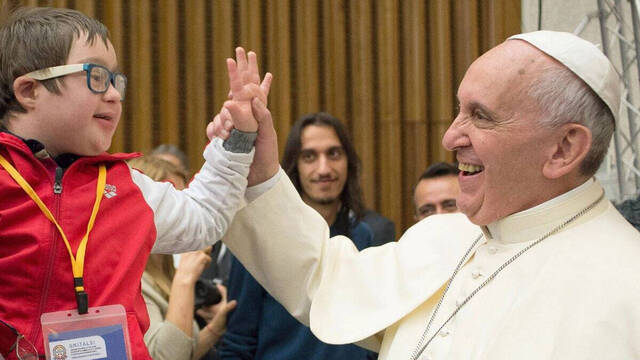 El Papa Francisco junto a una persona con discapacidad.