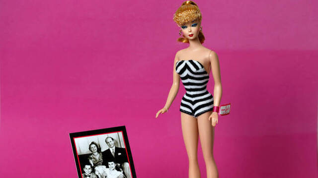 Primer modelo de Barbie junto a una foto de la familia creadora.