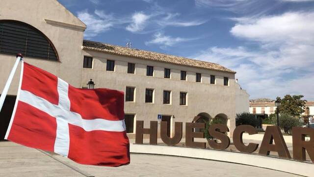 Bandera de Dinamarca y cartel del pueblo de Huéscar (Granada).